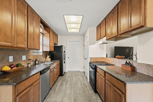 kitchen featuring light wood finished floors, decorative backsplash, appliances with stainless steel finishes, a sink, and under cabinet range hood