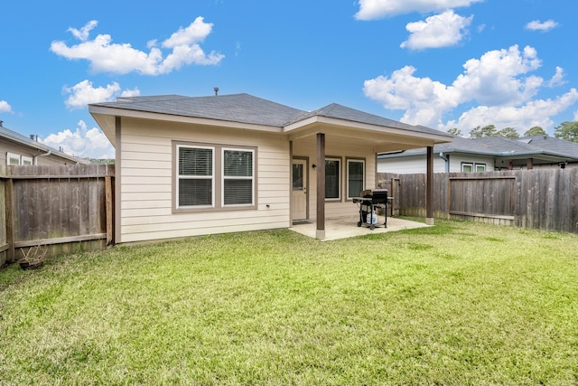 rear view of property with a patio, a lawn, and a fenced backyard