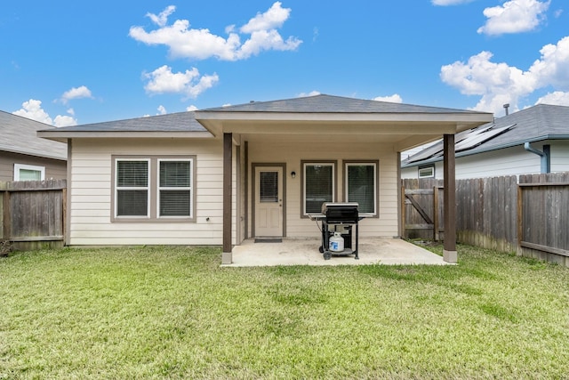 back of house featuring a fenced backyard, a yard, and a patio