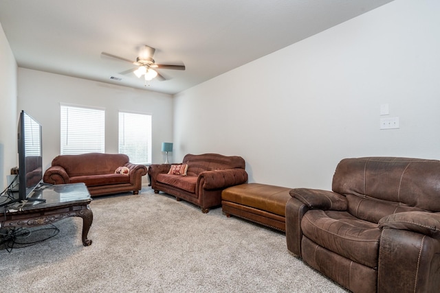 living room featuring visible vents, a ceiling fan, and light colored carpet