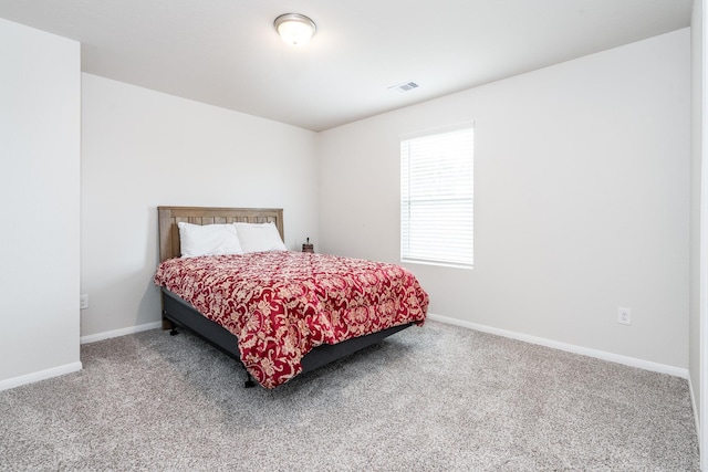 carpeted bedroom with visible vents and baseboards