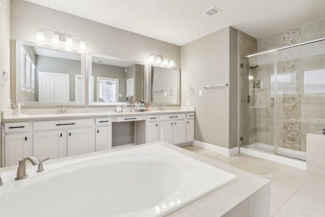 bathroom featuring tile patterned flooring, a garden tub, a stall shower, and a sink