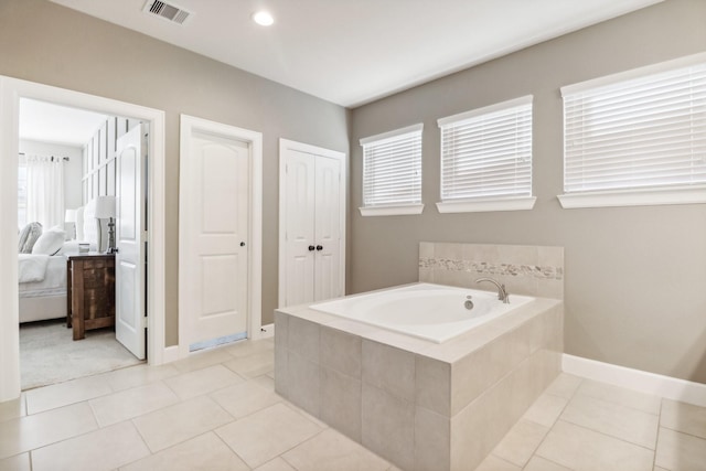 bathroom featuring ensuite bath, a bath, visible vents, and tile patterned floors