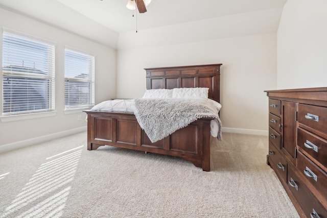 bedroom featuring light colored carpet, baseboards, and ceiling fan