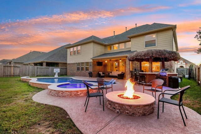 back of house at dusk with brick siding, a fenced in pool, an outdoor fire pit, a fenced backyard, and a patio area