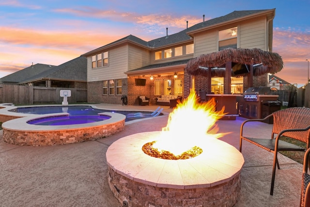 view of pool with fence, a fire pit, a grill, an in ground hot tub, and a patio area