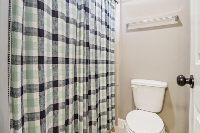 full bath with a shower with shower curtain and toilet