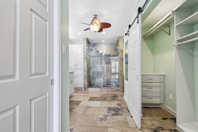 full bath with recessed lighting, a ceiling fan, stone finish floor, a shower stall, and vanity