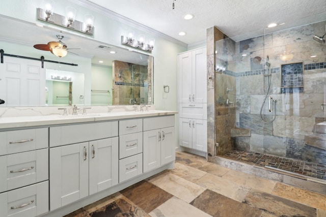 full bath with a textured ceiling, a sink, ornamental molding, a shower stall, and double vanity