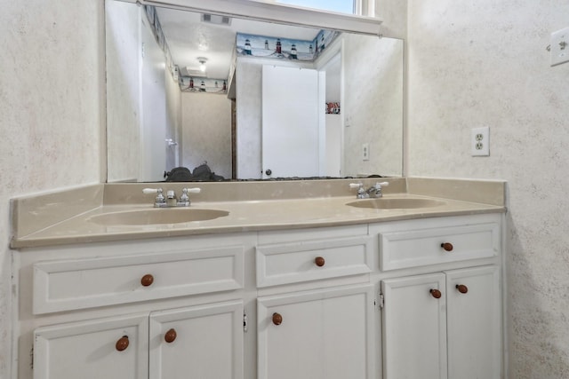 bathroom featuring visible vents, a sink, and double vanity