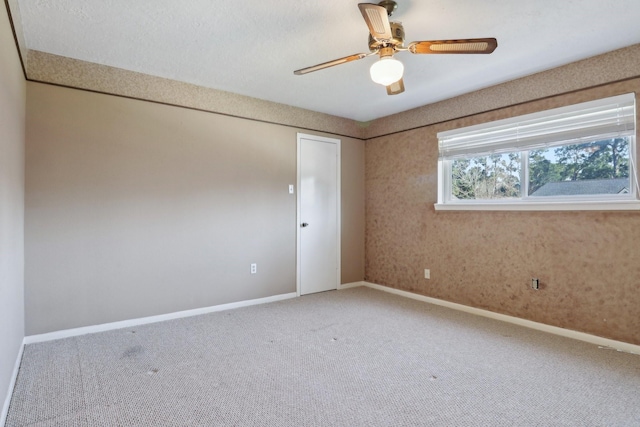 empty room featuring carpet floors, baseboards, and ceiling fan