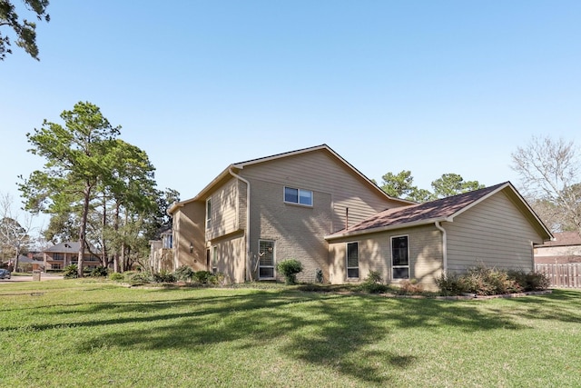 rear view of house with a yard and brick siding