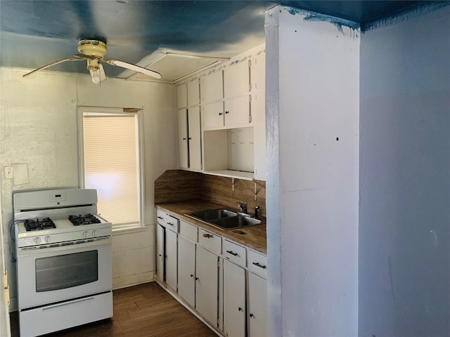 kitchen with white range with gas stovetop, a ceiling fan, dark wood-type flooring, white cabinetry, and a sink