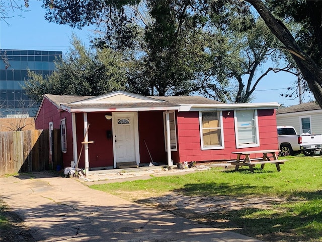 ranch-style house featuring a front yard and fence