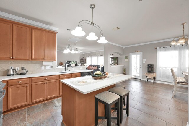 kitchen with tasteful backsplash, light countertops, an inviting chandelier, a sink, and plenty of natural light