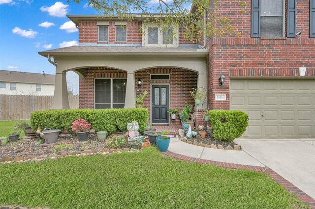 view of front facade with a porch, a front yard, brick siding, and fence