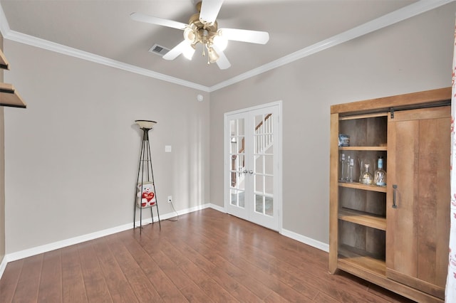 empty room featuring ornamental molding, wood-type flooring, visible vents, and ceiling fan