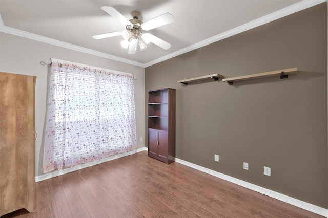 unfurnished room with ceiling fan, ornamental molding, wood finished floors, and baseboards