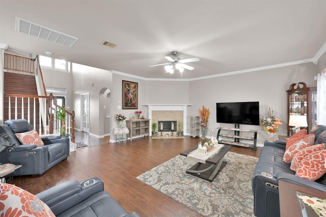 living area with arched walkways, stairway, wood finished floors, and visible vents