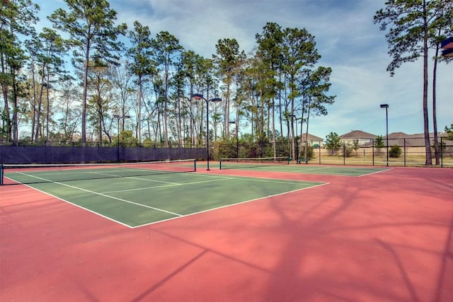 view of tennis court with community basketball court and fence