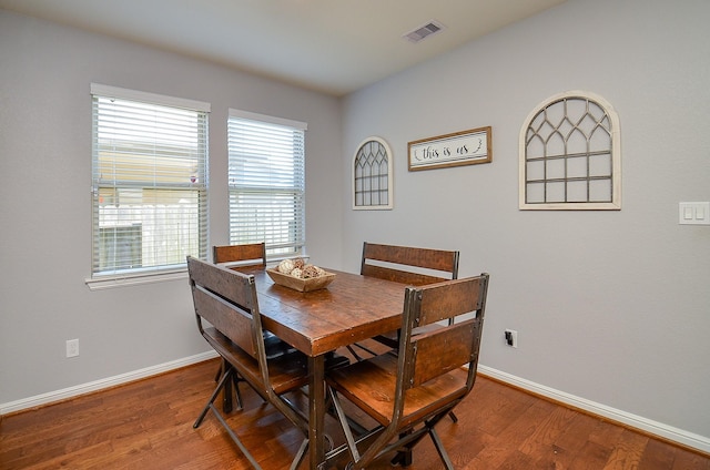 dining space with visible vents, baseboards, and wood finished floors