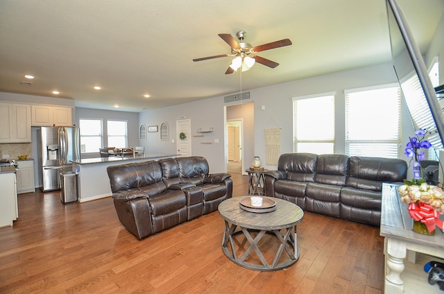 living room featuring ceiling fan, wood finished floors, visible vents, and recessed lighting