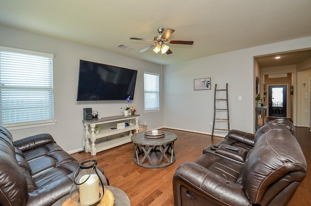 living room featuring a ceiling fan, baseboards, visible vents, and wood finished floors