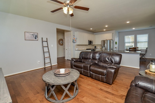 living area featuring light wood-style floors, ceiling fan, baseboards, and recessed lighting