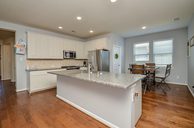 kitchen with stainless steel appliances, white cabinets, and visible vents