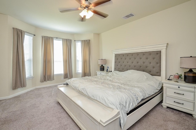 bedroom featuring light carpet, a ceiling fan, visible vents, and baseboards