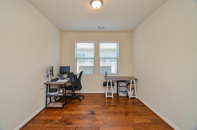 office space featuring wood finished floors, visible vents, and baseboards