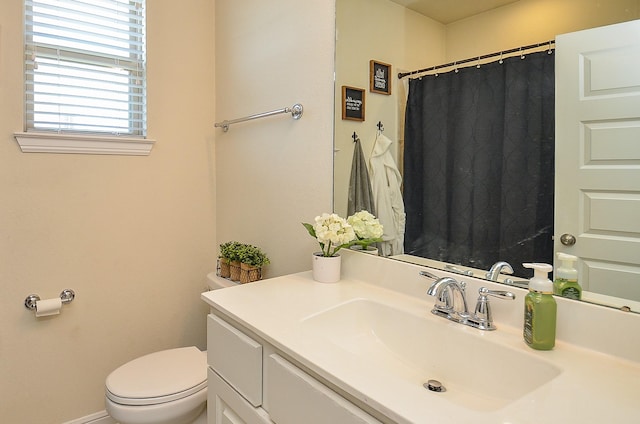 bathroom with toilet, a shower with shower curtain, and vanity