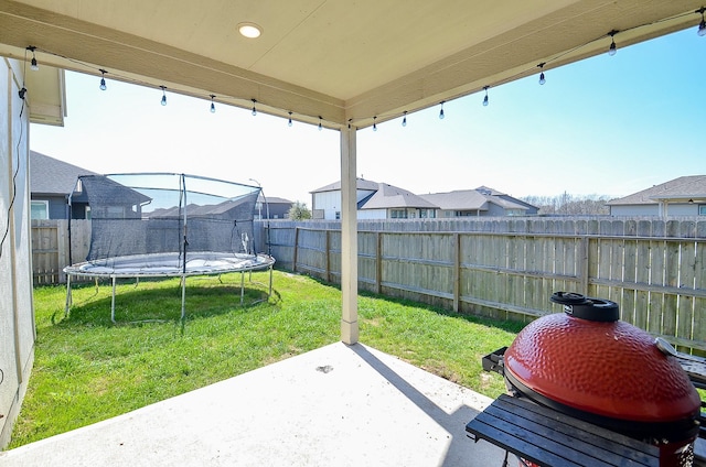 view of patio / terrace with a fenced backyard, a trampoline, and area for grilling