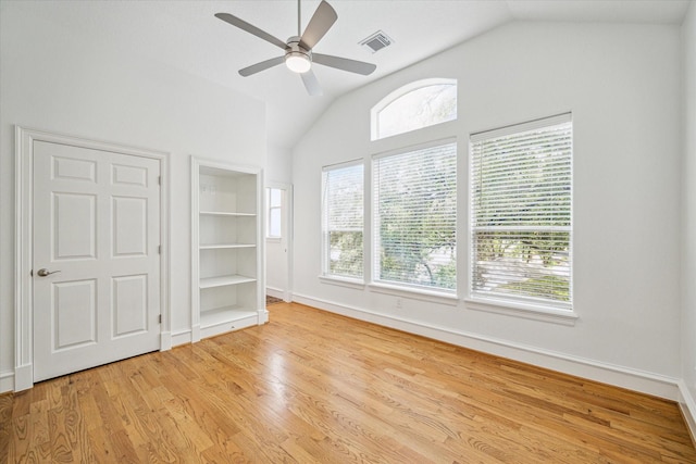 interior space with visible vents, baseboards, lofted ceiling, wood finished floors, and a ceiling fan