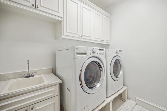 laundry area with washer and clothes dryer, cabinet space, and a sink