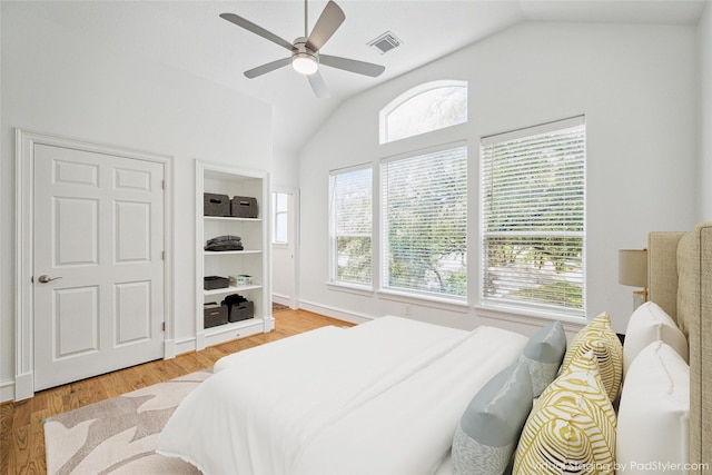 bedroom featuring visible vents, a ceiling fan, lofted ceiling, and wood finished floors