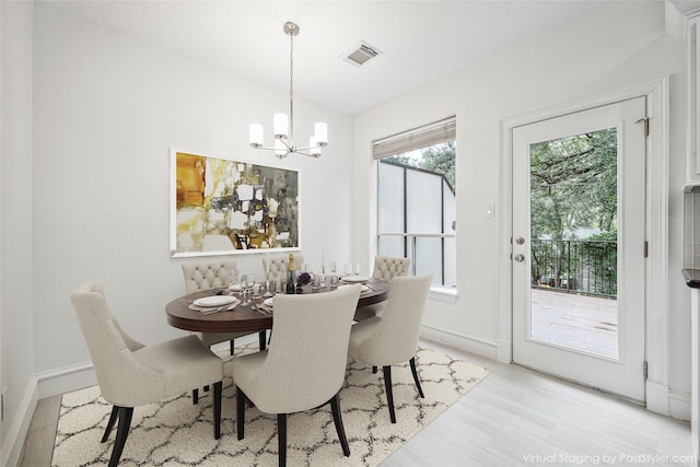 dining room with lofted ceiling, a notable chandelier, baseboards, and visible vents