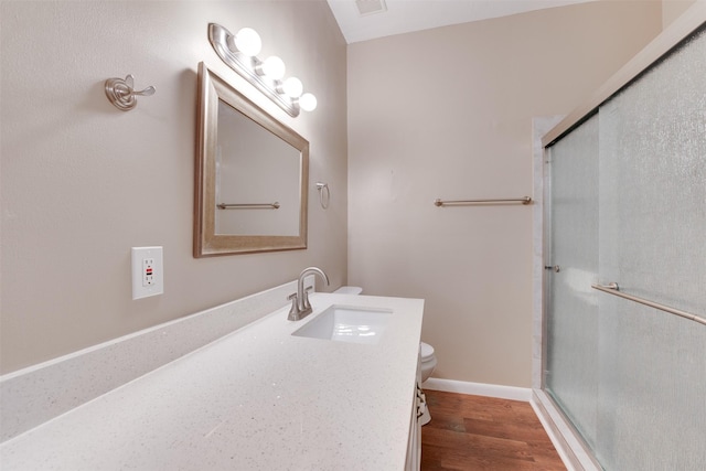 full bathroom with vanity, a shower stall, toilet, and wood finished floors