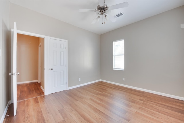 spare room featuring attic access, visible vents, baseboards, light wood-style flooring, and ceiling fan