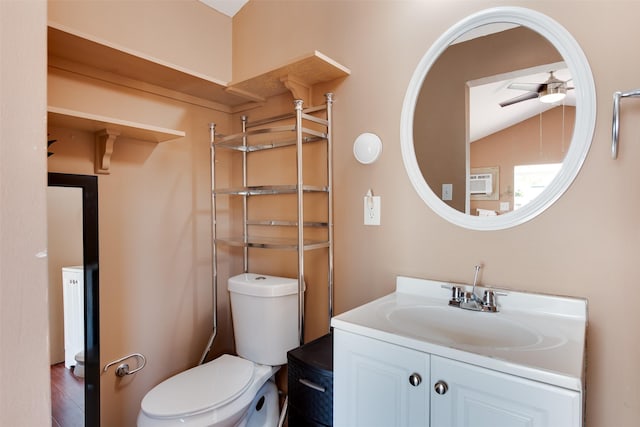 bathroom featuring toilet, vaulted ceiling, and vanity