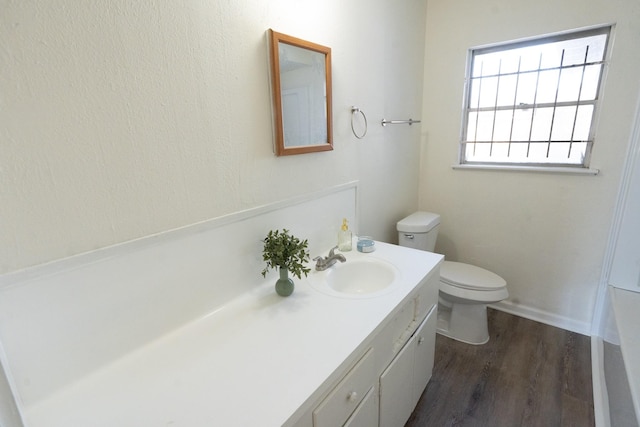 bathroom featuring toilet, wood finished floors, and vanity