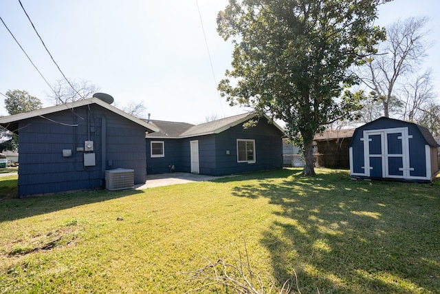 rear view of house with a storage unit, a yard, central air condition unit, a patio area, and an outdoor structure