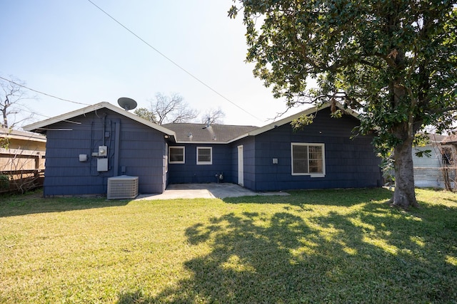 rear view of property featuring a patio, fence, central AC, and a yard