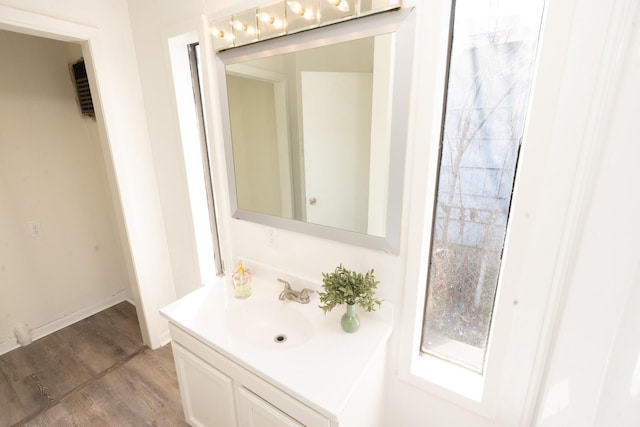 bathroom featuring baseboards, wood finished floors, and vanity