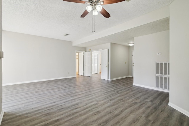 unfurnished room with dark wood-style floors, visible vents, and baseboards