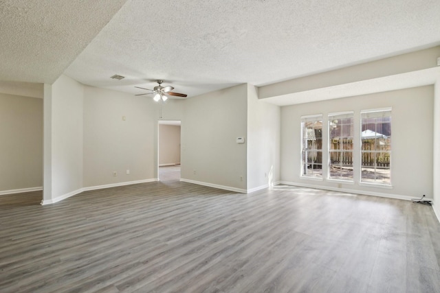 unfurnished living room with ceiling fan, a textured ceiling, wood finished floors, and baseboards