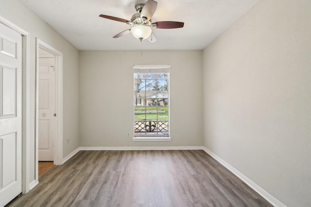 unfurnished bedroom featuring wood finished floors, a ceiling fan, and baseboards