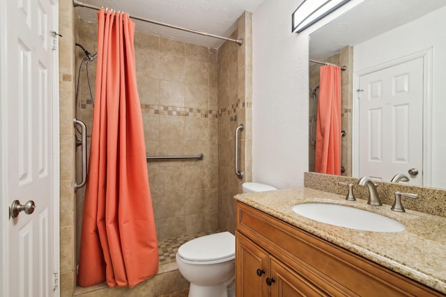 bathroom with toilet, tiled shower, and vanity