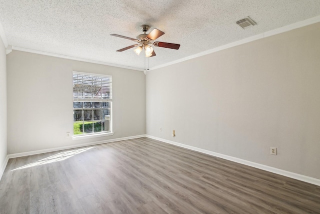 spare room with ornamental molding, dark wood-style flooring, and visible vents