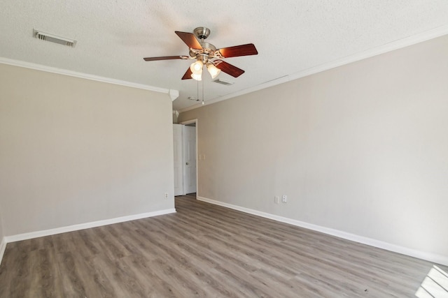 spare room featuring baseboards, visible vents, ceiling fan, wood finished floors, and a textured ceiling